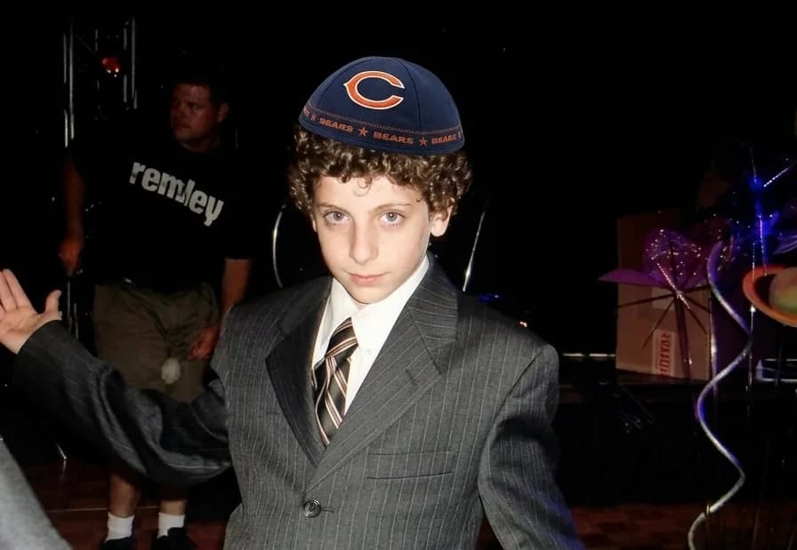 Jacob in a suit and Chicago Bears cap